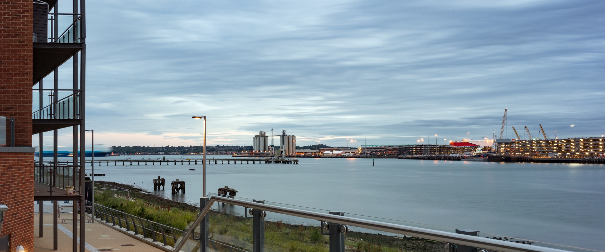 Southampton waterfront at dusk, looking across calm water toward the port.